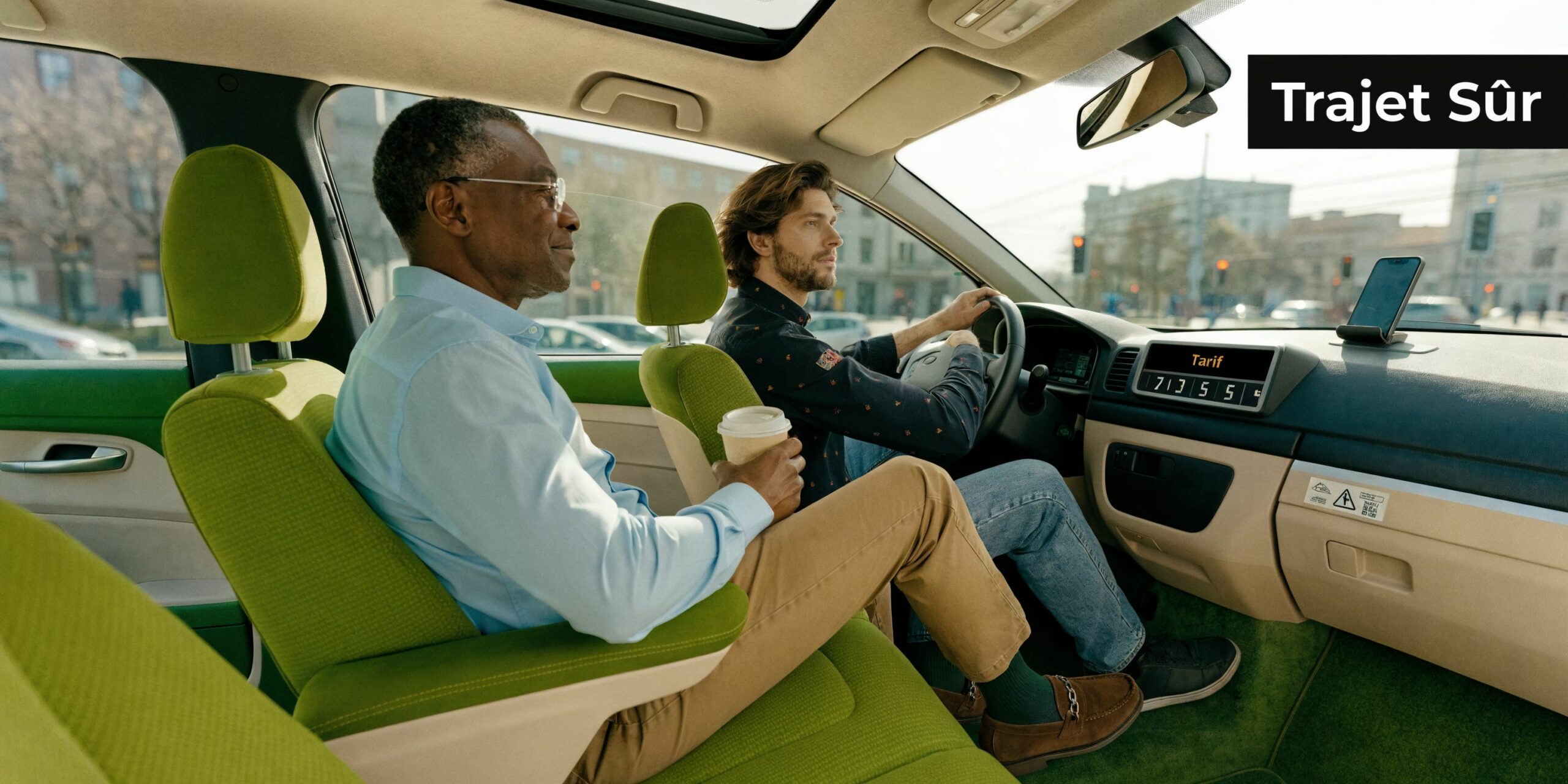Deux hommes discutent confortablement dans un taxi moderne aux sièges verts lors d'un trajet urbain.